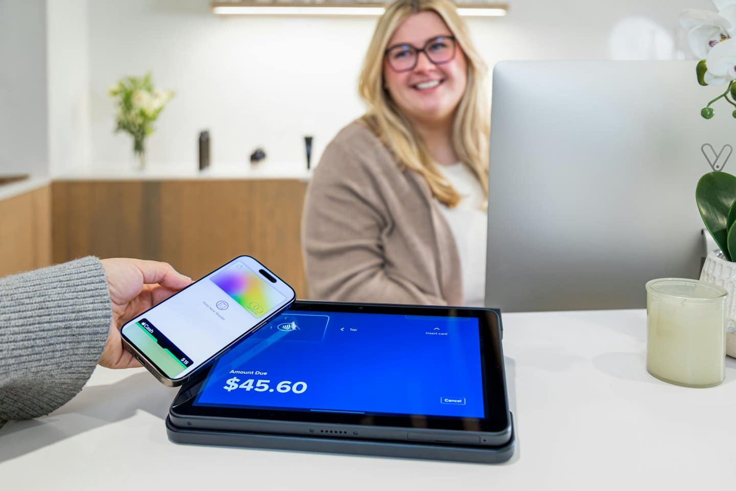 Customer uses a smartphone for contactless payment on a tablet.