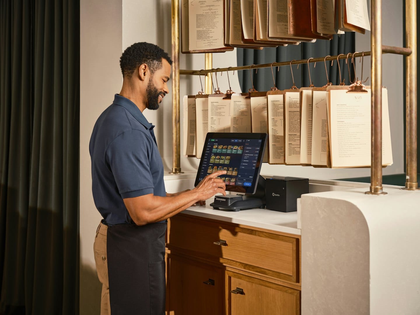 Employee wearing an apron uses a restaurant point-of-sale system.